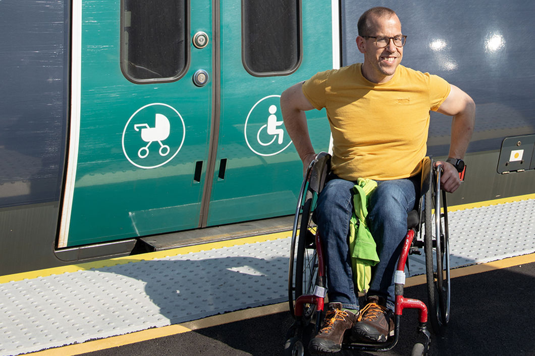 Mann i rullestol foran tog