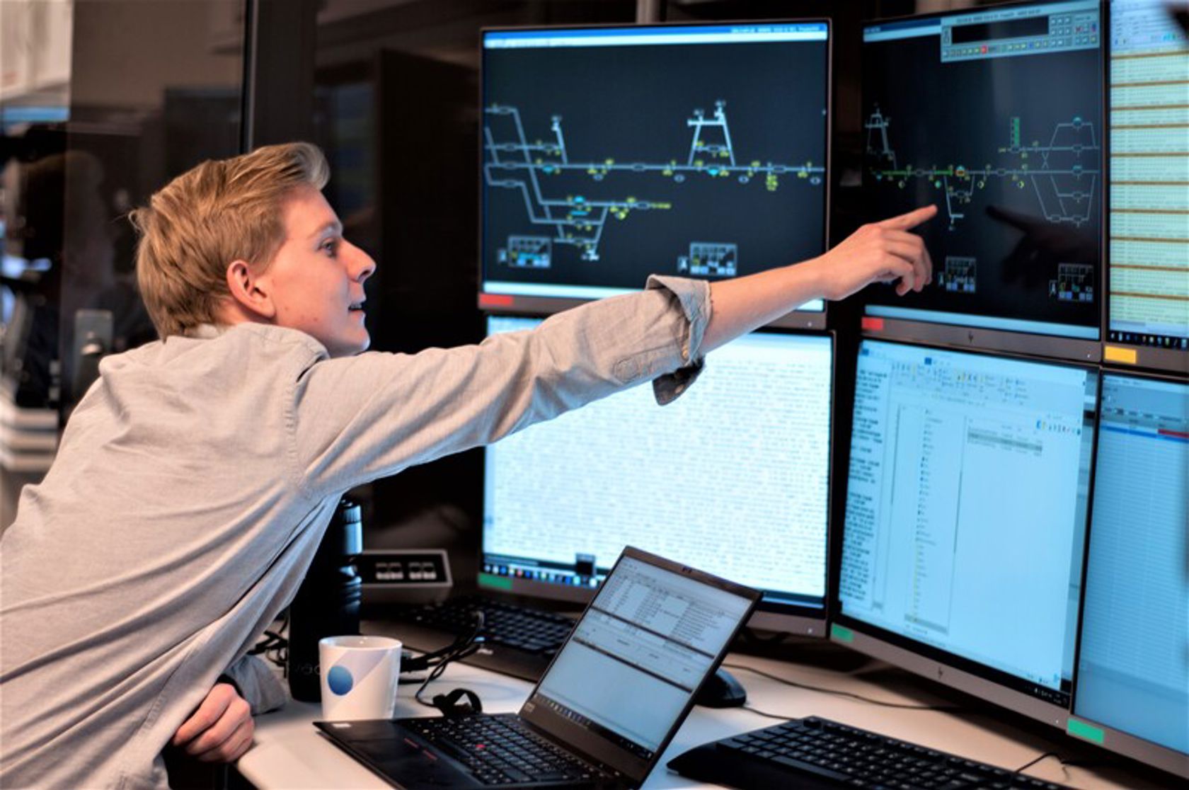 Mann som peker på skjermer over digitalt signalsystem.
