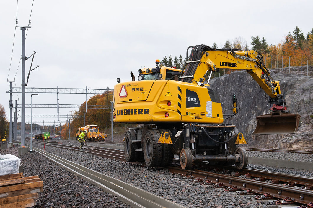Gravemaskin som går på jernbaneskinner