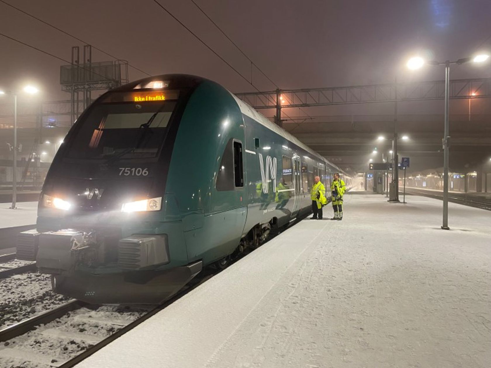 Bildet av et tog som står på perrongen en vinterkveld i januar.