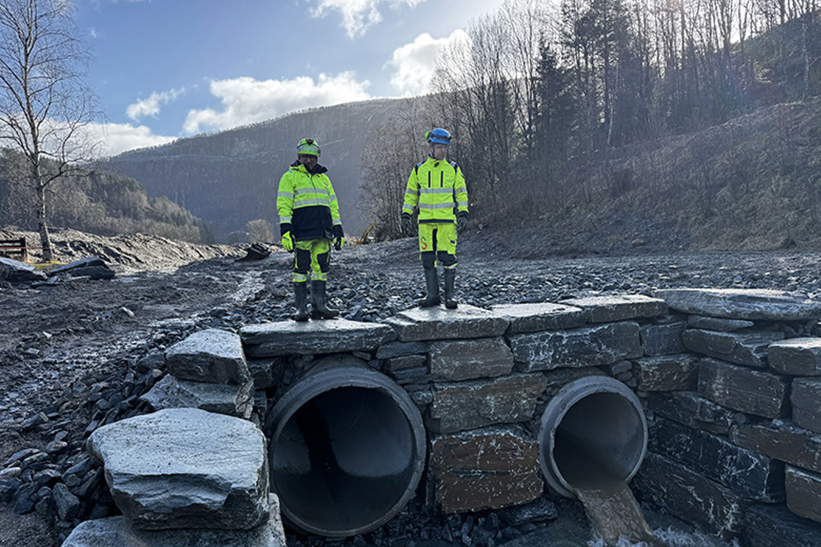 To menn oppå to utløpsrør