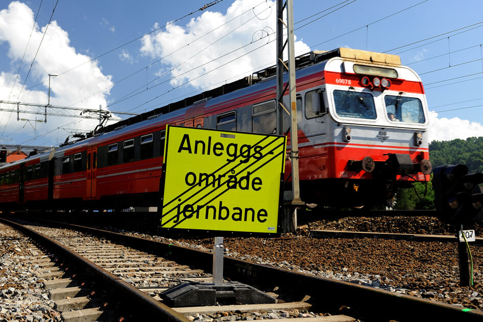 Nærbilde av tog og skilt hvor det står anleggsområde jernbane