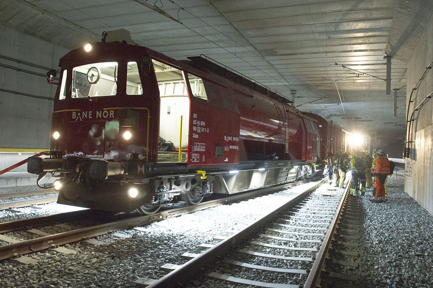 Bilde av et helt rødt tog inne i en tunnel. Toget har påskrevet teksten "Bane NOR".