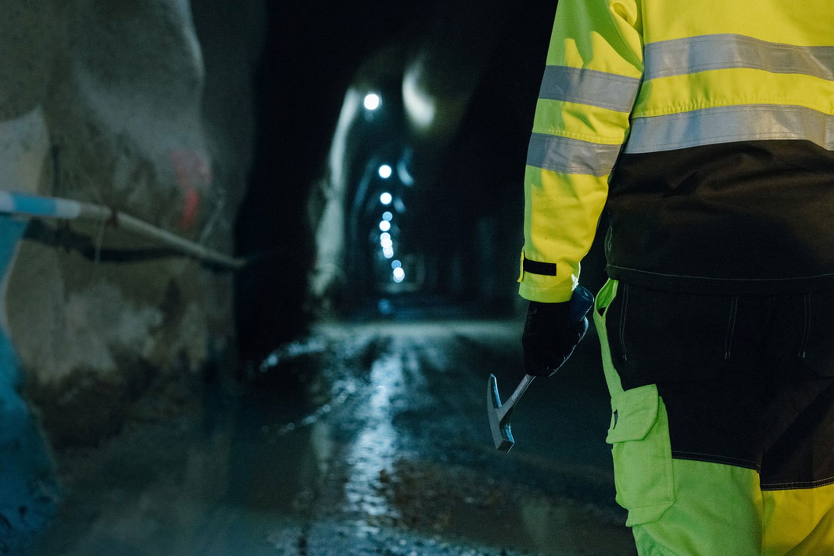 Person i gult vernetøy i tunnell for å gjøre vedlikeholdsarbeid på jernbanen.