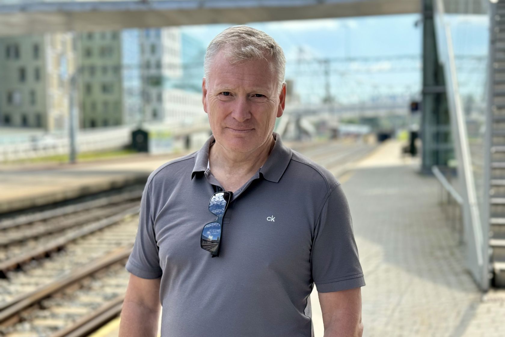 Portrett av Frode Teigen på plattform med togskinner i bakgrunnen