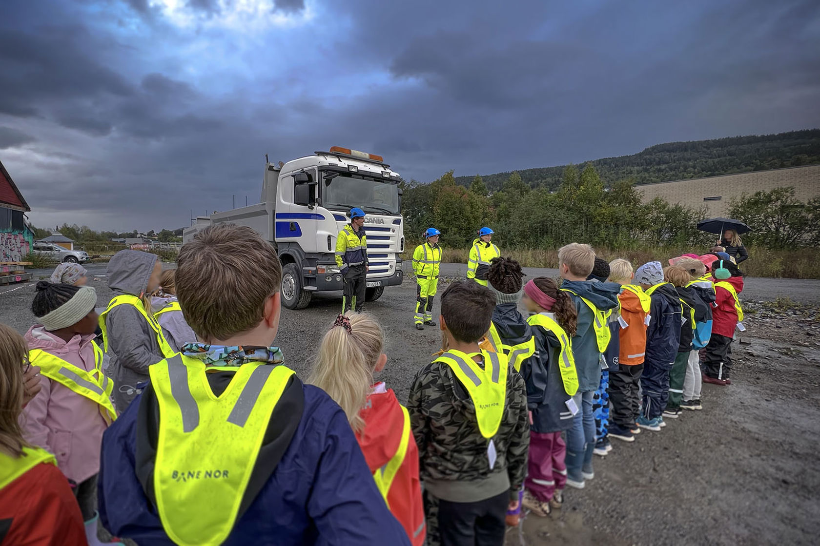 Bilde av lastebil og Bane NOR-folk som snakker til barn
