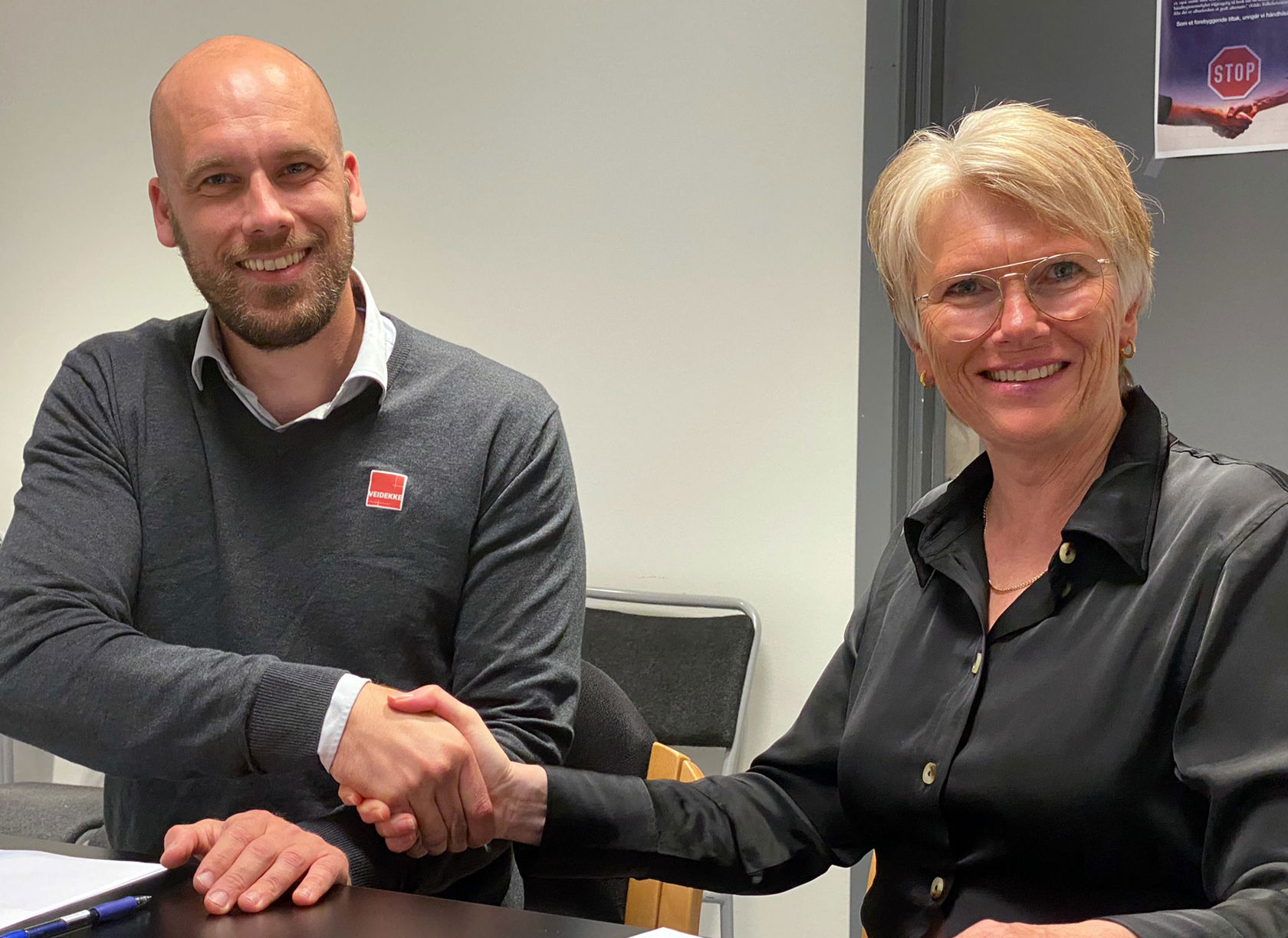Magnus Sutherland Kristensen og Hanne Stormo utveksler håndtrykk etter å ha signert kontrakt.