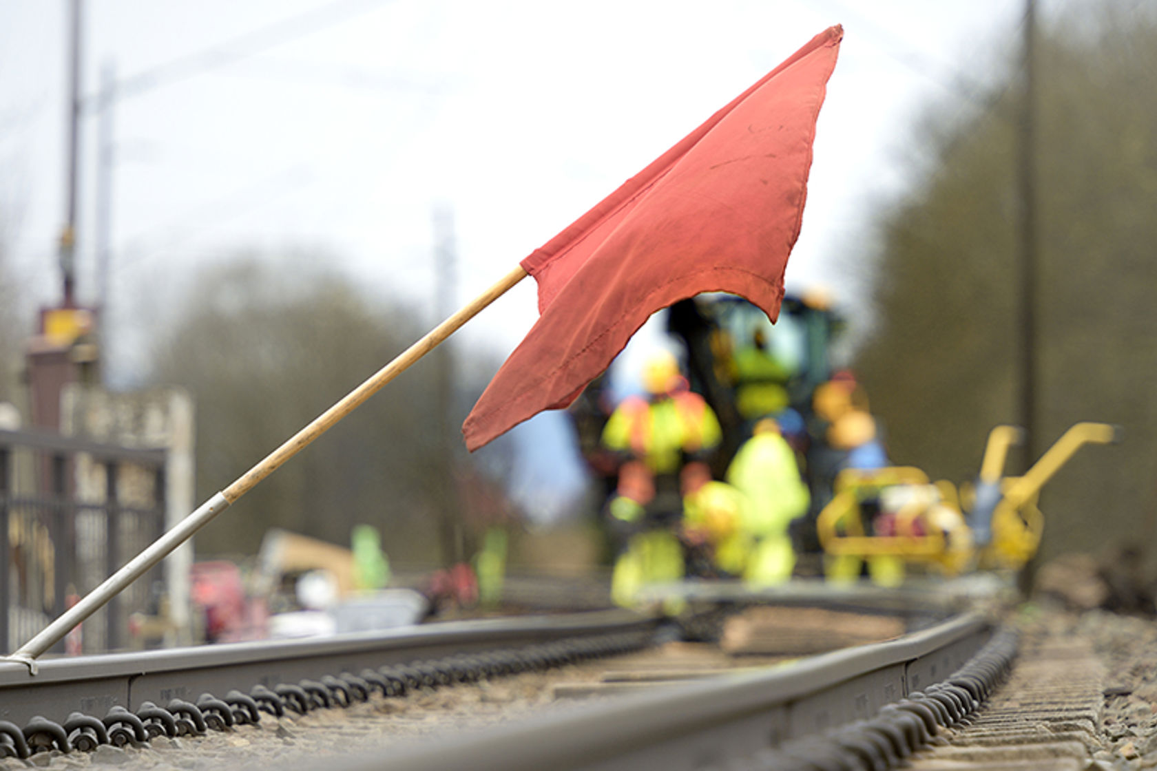 Bilde av et rødt flagg som står over skinnegangen på jernbanen.