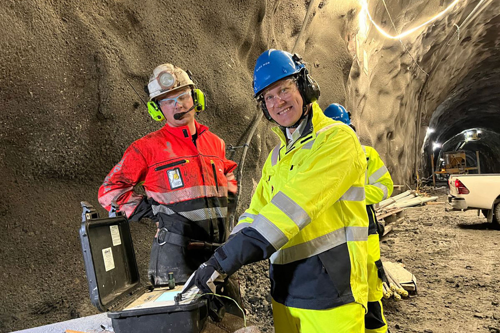 I ført hjelm og vernetøy trykker statsråden på knappen som fyrer av salva. Skytebas passer på.