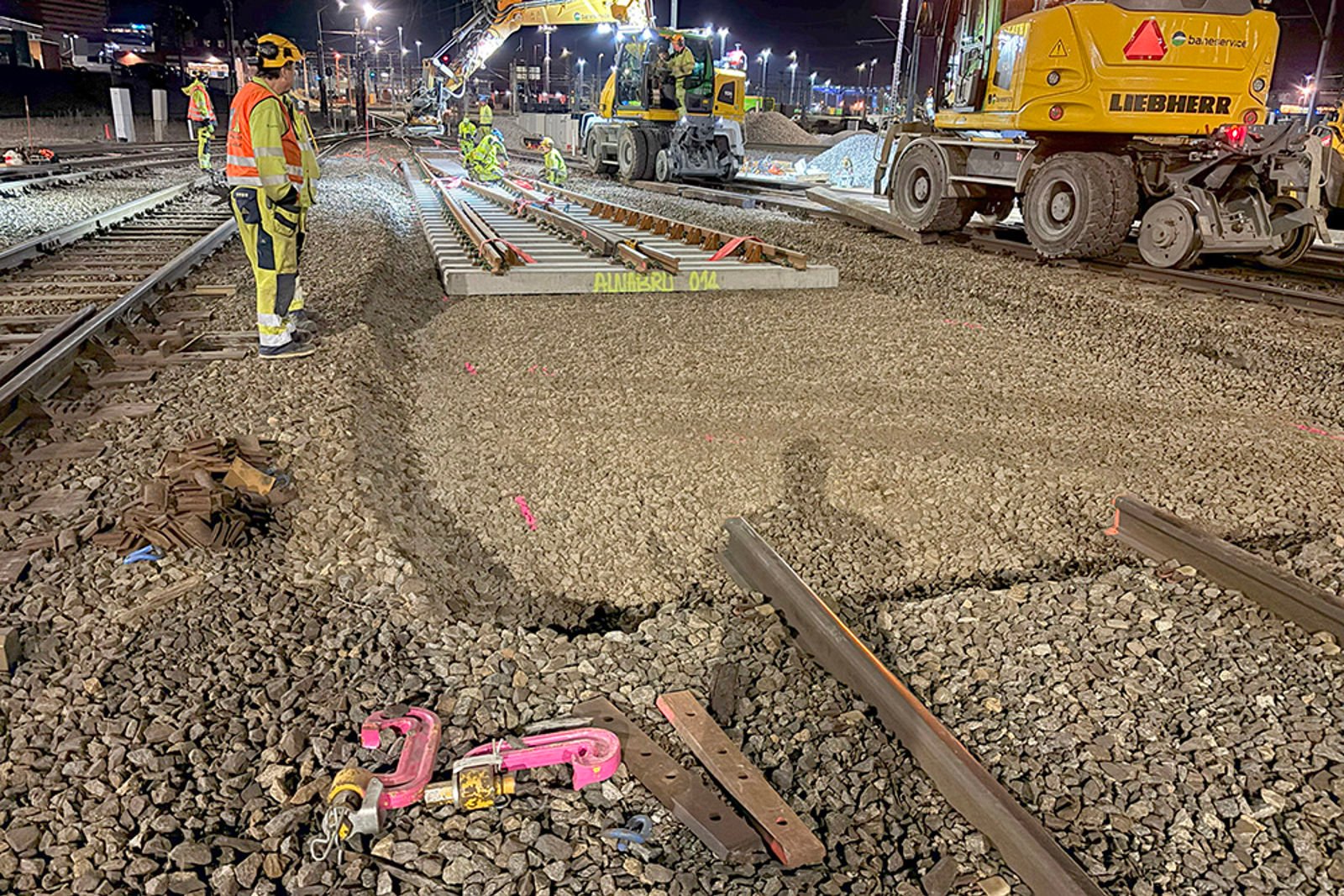 Skinnegående gravemaskiner har løftet inn vekselen, mannskap i arbeid.