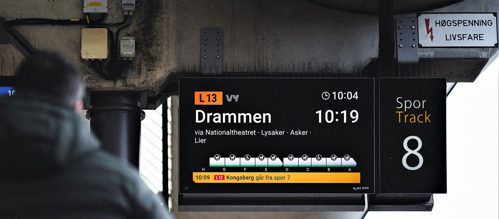 Reisende ser på skjerm på plattform.