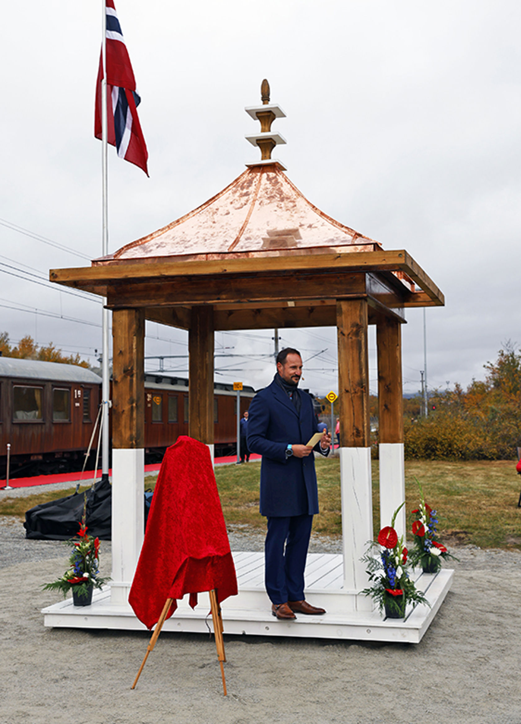 HKH Kronprins Haakon holder tale i Hjerkinn stasjons gjenoppbygde paviljong med kobbertak. 