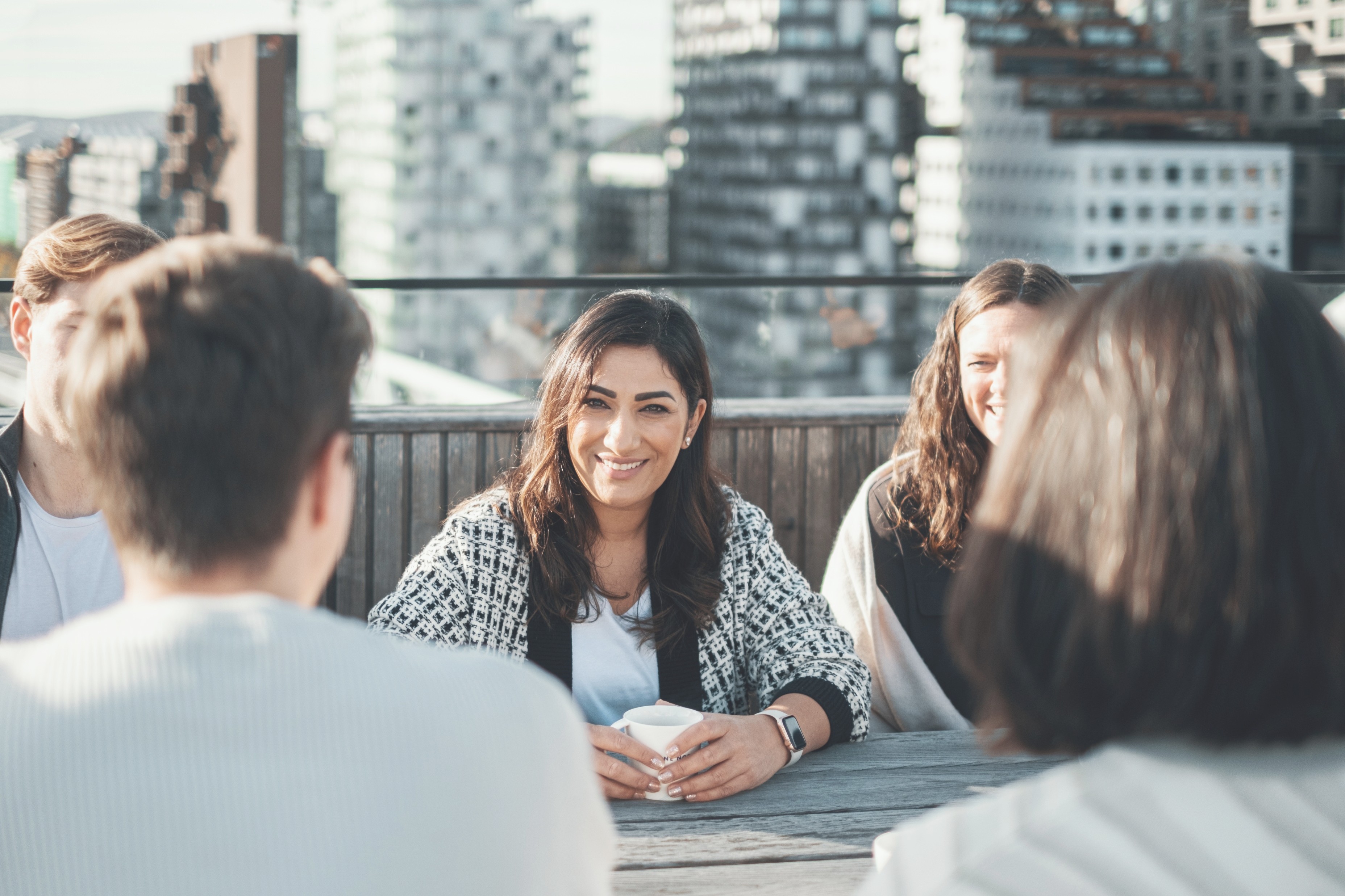 Fem ansatte i Bane NOR er samlet på taket for en sosial prat