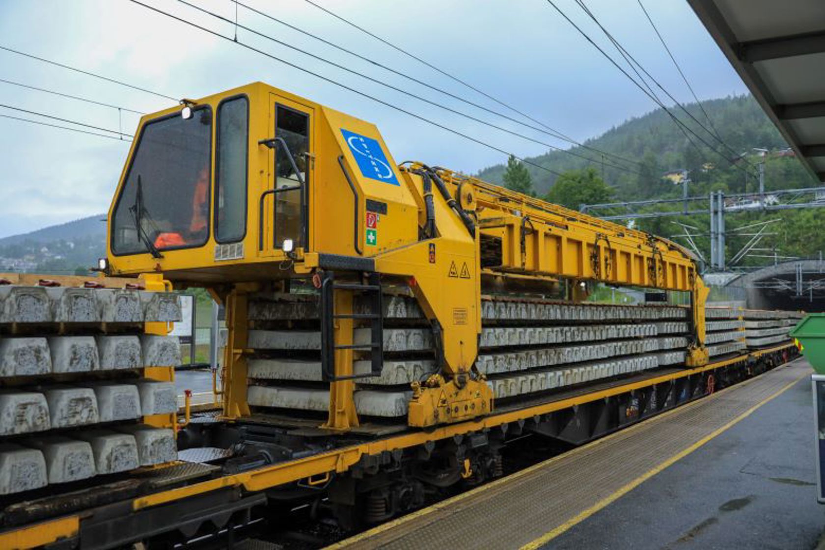 Et gult arbeidstog som står i et jernbanespor. 