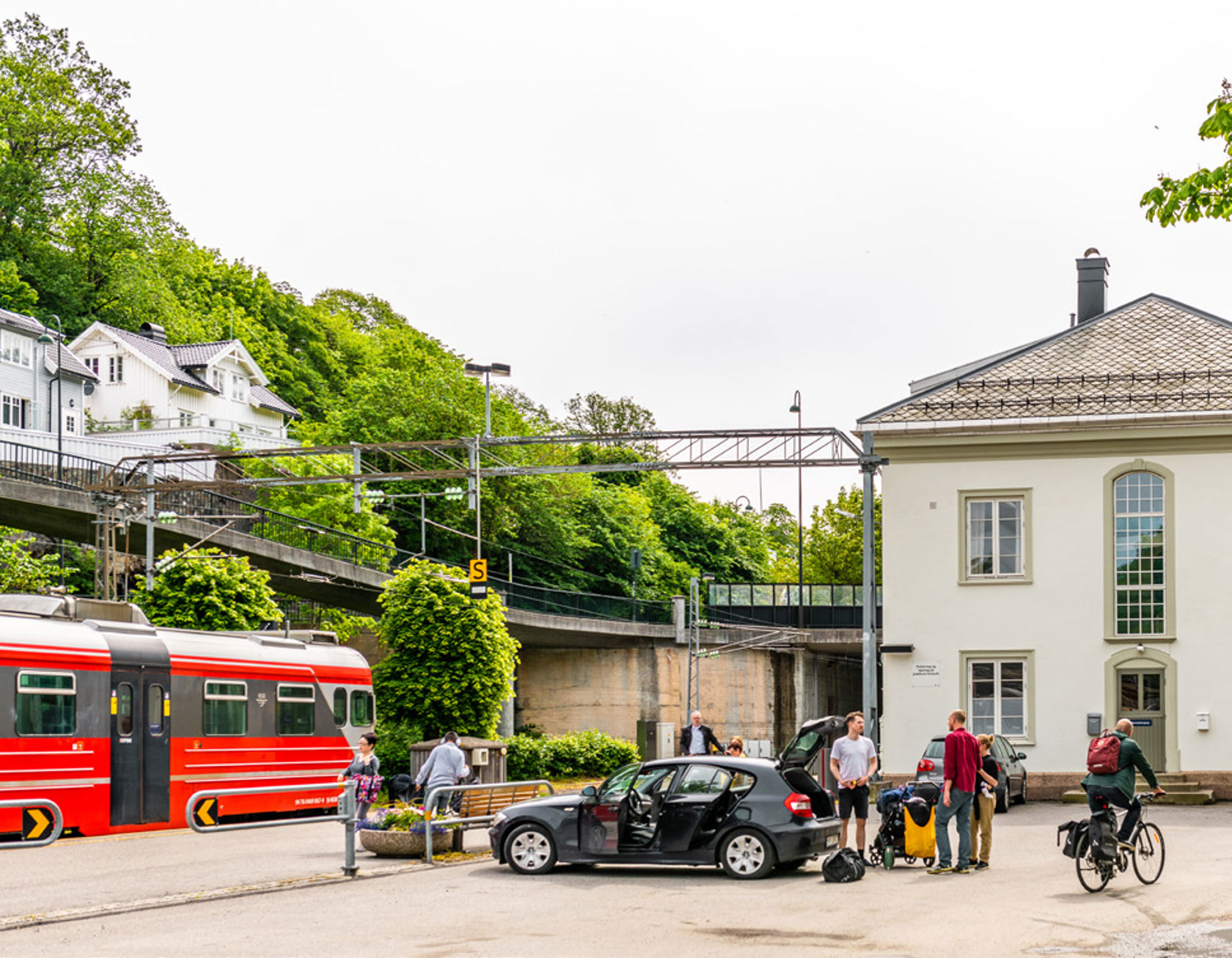 Bilde av togstasjon med parkert bil.