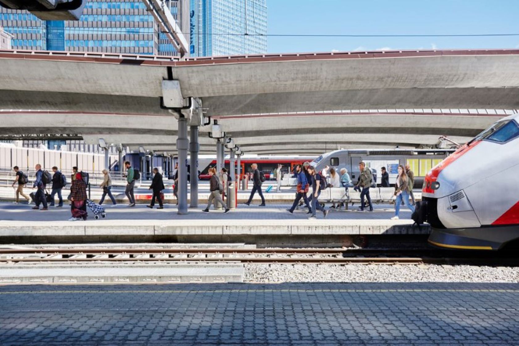Passasjerer går av et tog og på en plattform på en jernbanestasjon