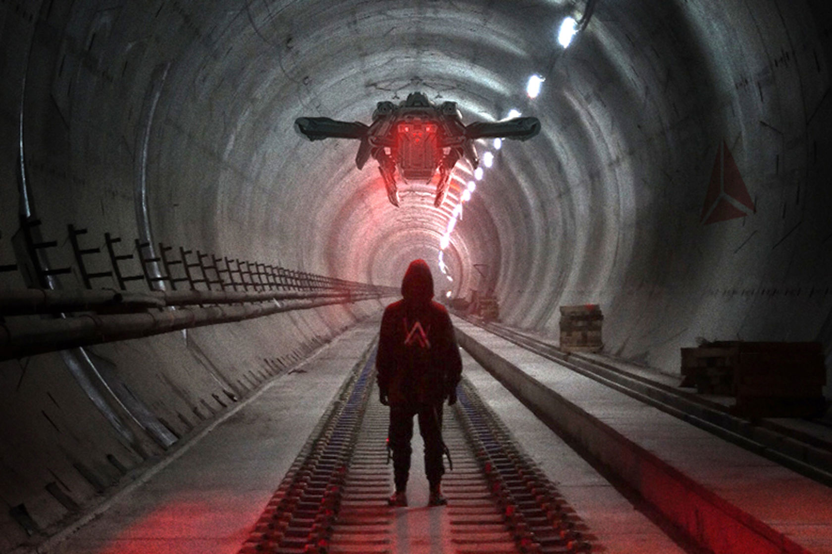 Bilde av en mann som står med ryggen til i en tunnel. 