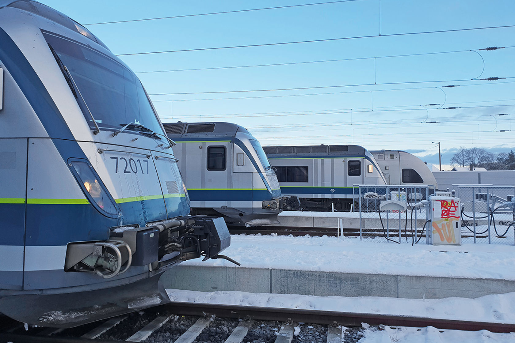 Vinterbilde med fronten på fire togsett side om side.