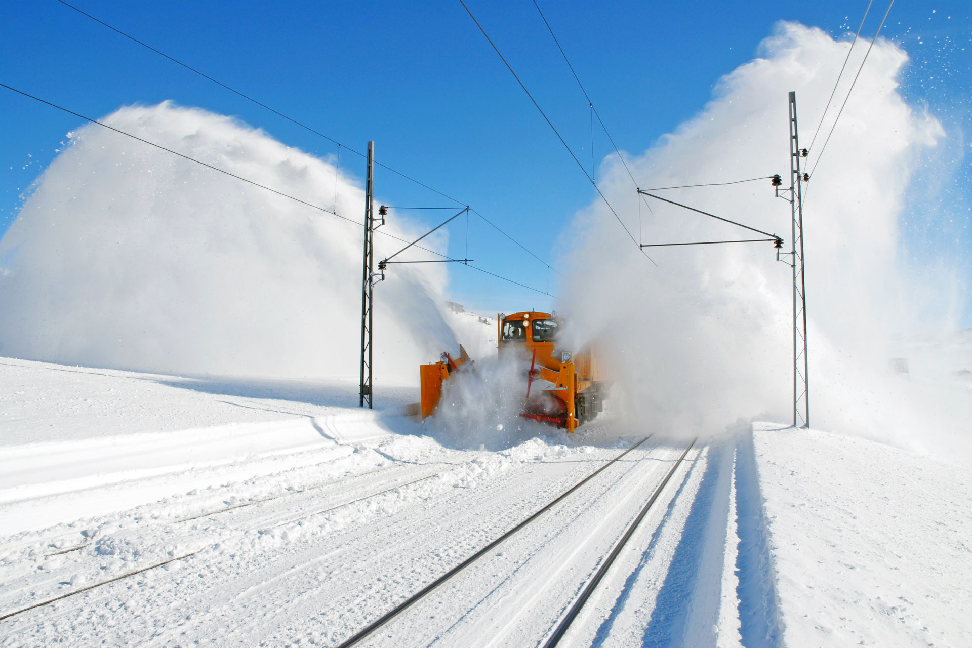 Eit arbeidstog på Finse mokar store snømenger frå toglinja, og snøsprøyten står