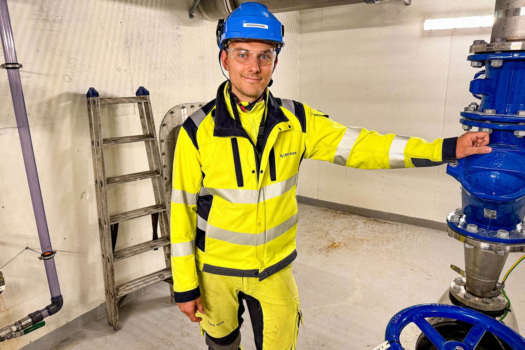 Mann i vernetøy lener seg mot pumpe.