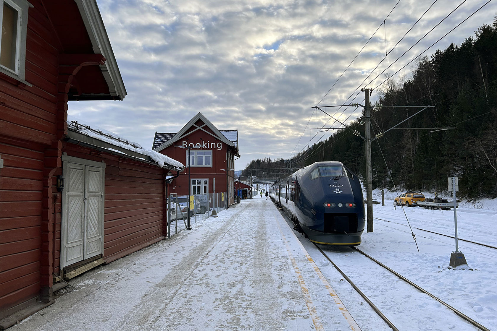 Plattform med godshus, stasjonsbygning og tog fra SJ Norge.