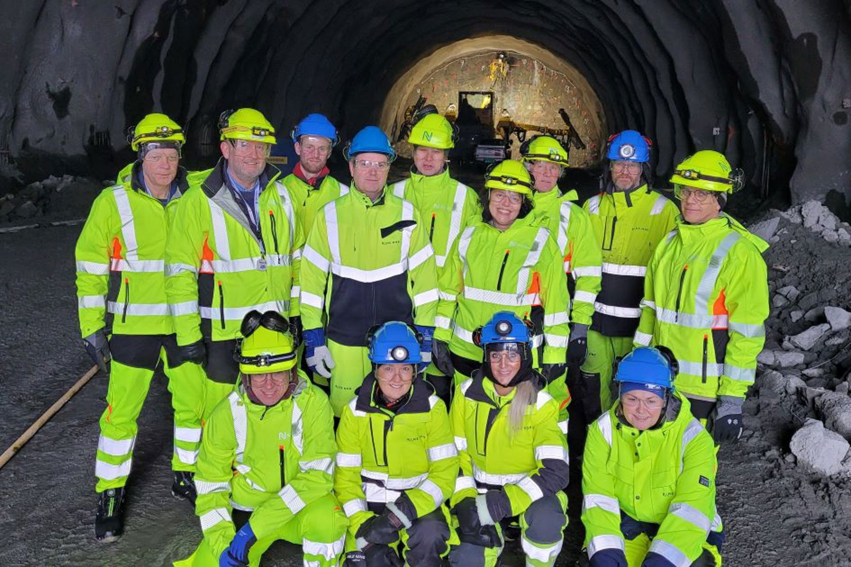 Bilde viser gruppebilde av en interessert gruppe med representanter fra Nye Veier og Bane NOR som tok turen inn de første 70 meterne som er sprengt av Hestnestunnelen så langt.