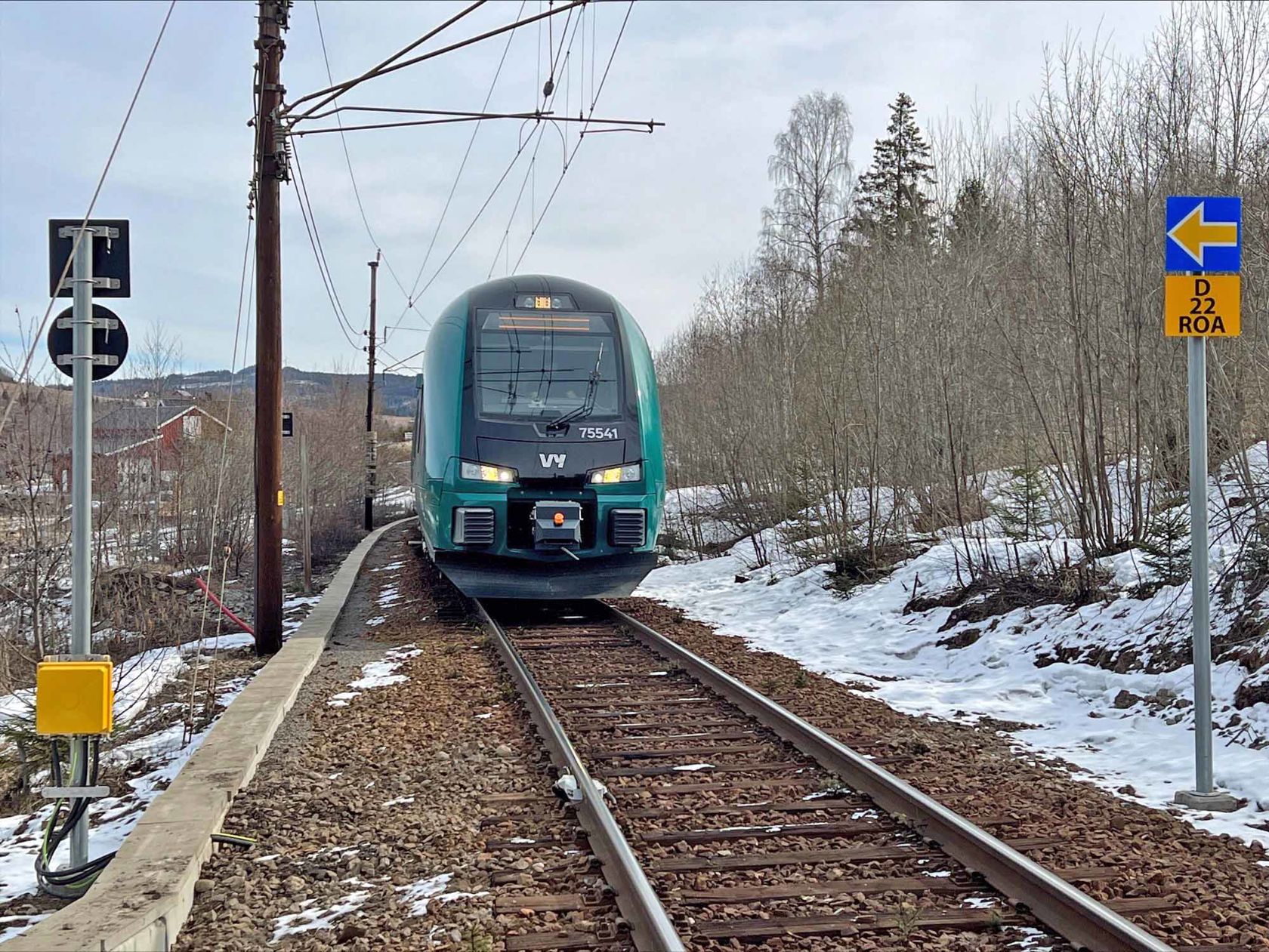 Passasjertog fra Vy foran nye blå og gule ERTMS-skilt i sporet.