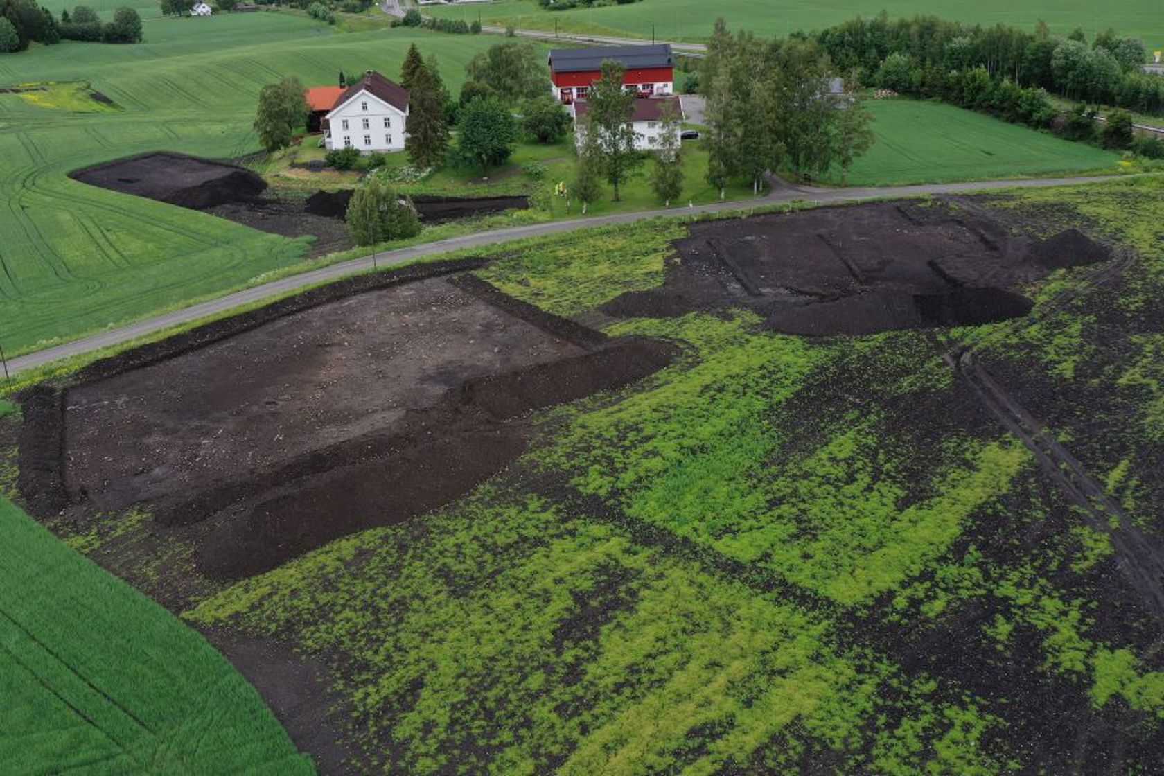 Dronefoto av Næsten gård med arkeologiske lokaliteter i forgrunnen. 