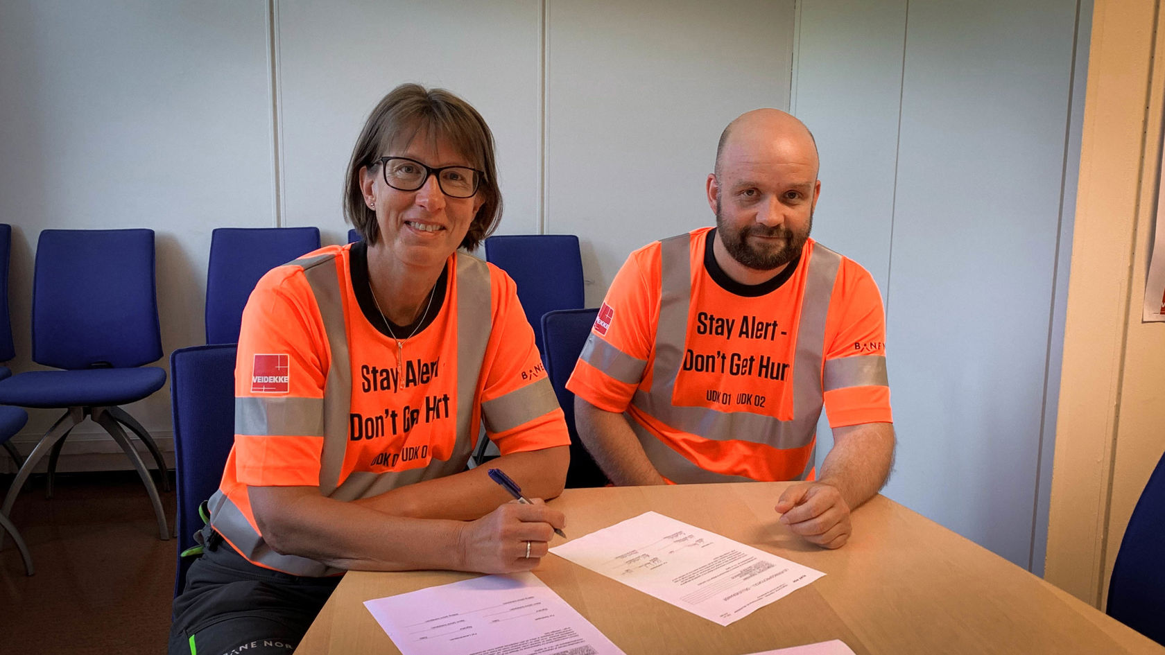 Bilde av en mann og en kvinne som signerer papirer.