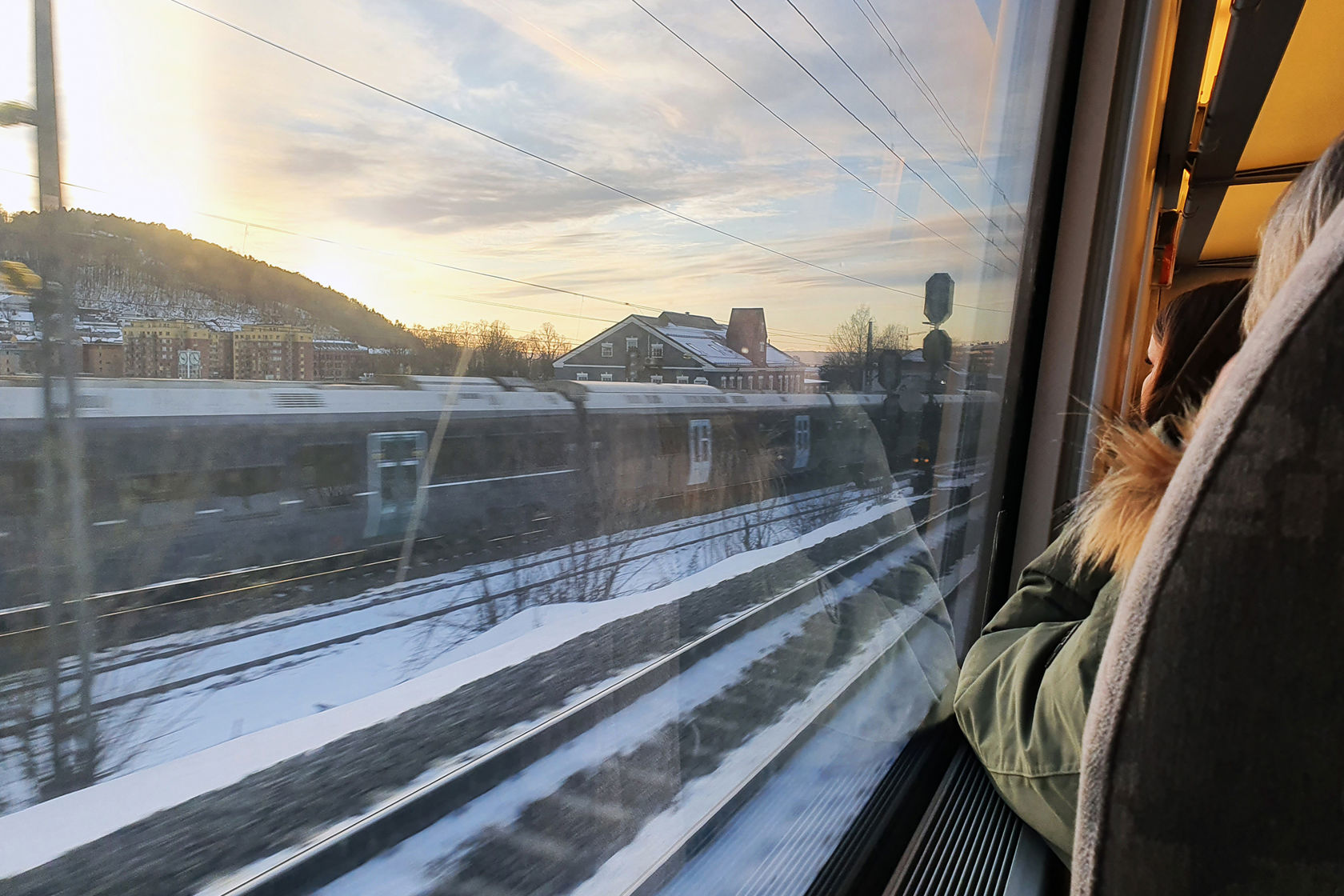 Foto tatt ombord i et tog i fart og med utsikt til togsporene utenfor