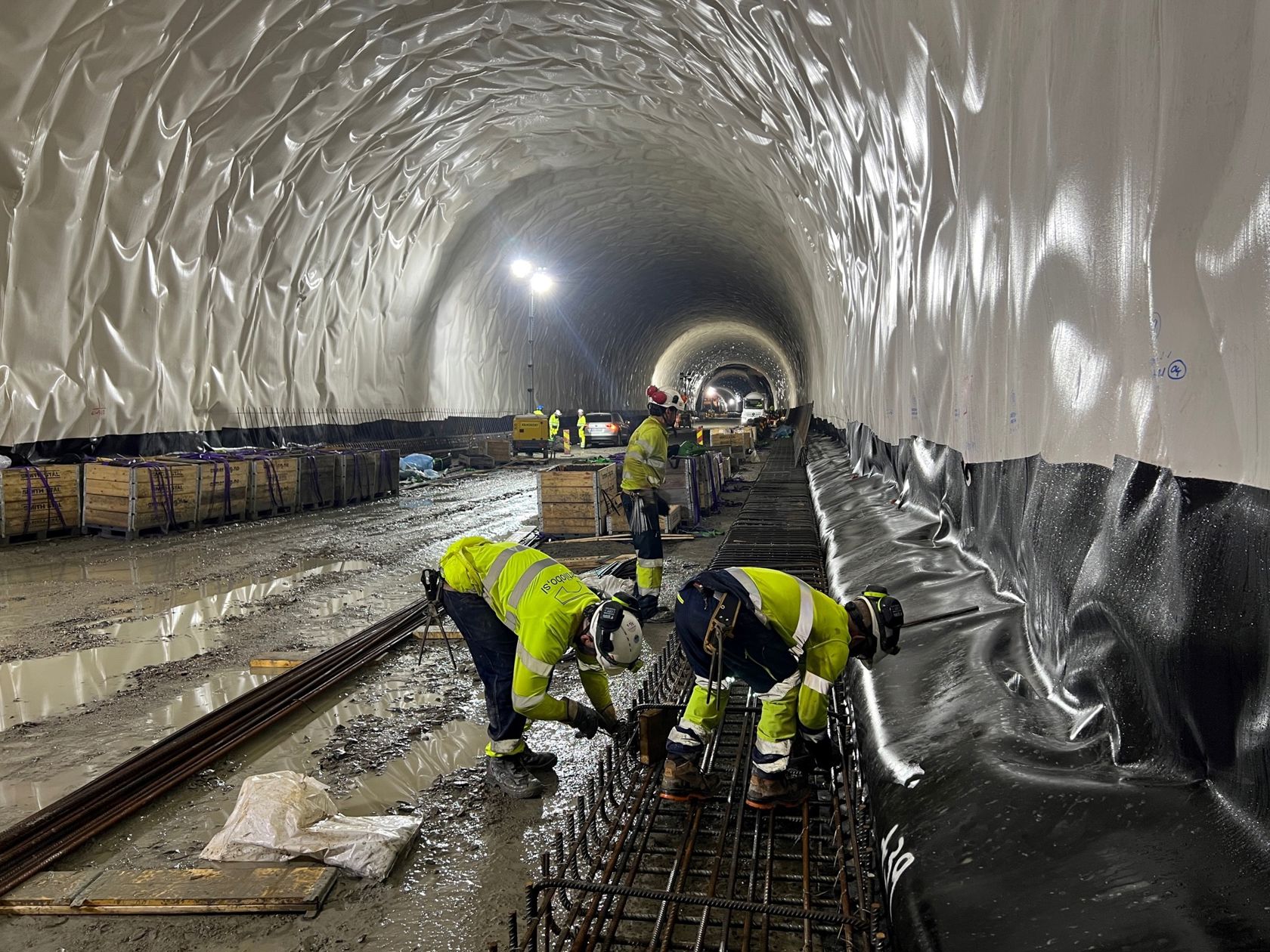 Bilde av arbeidere inne i en tunnel.
