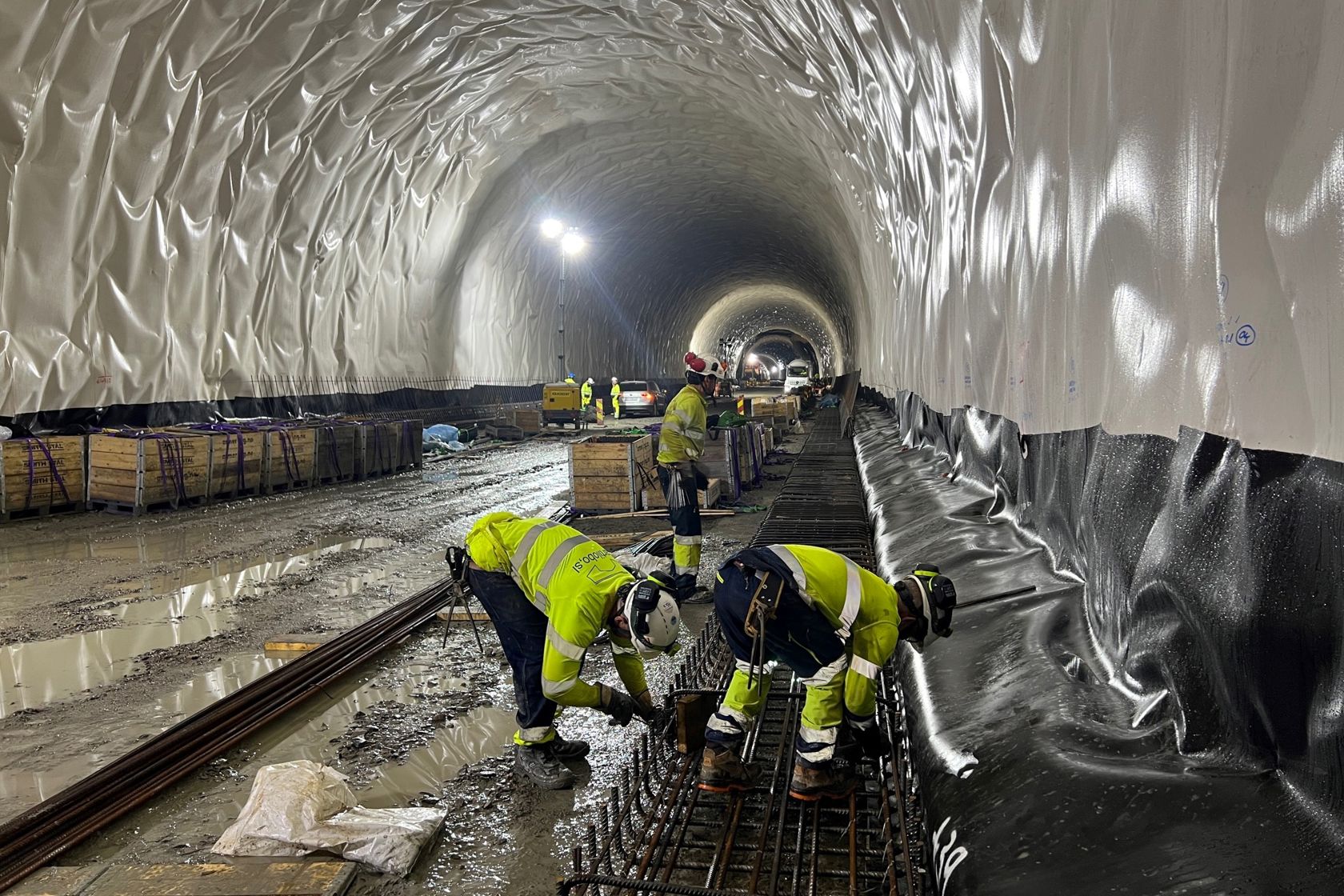 Bilde av arbeidere inne i en tunnel.