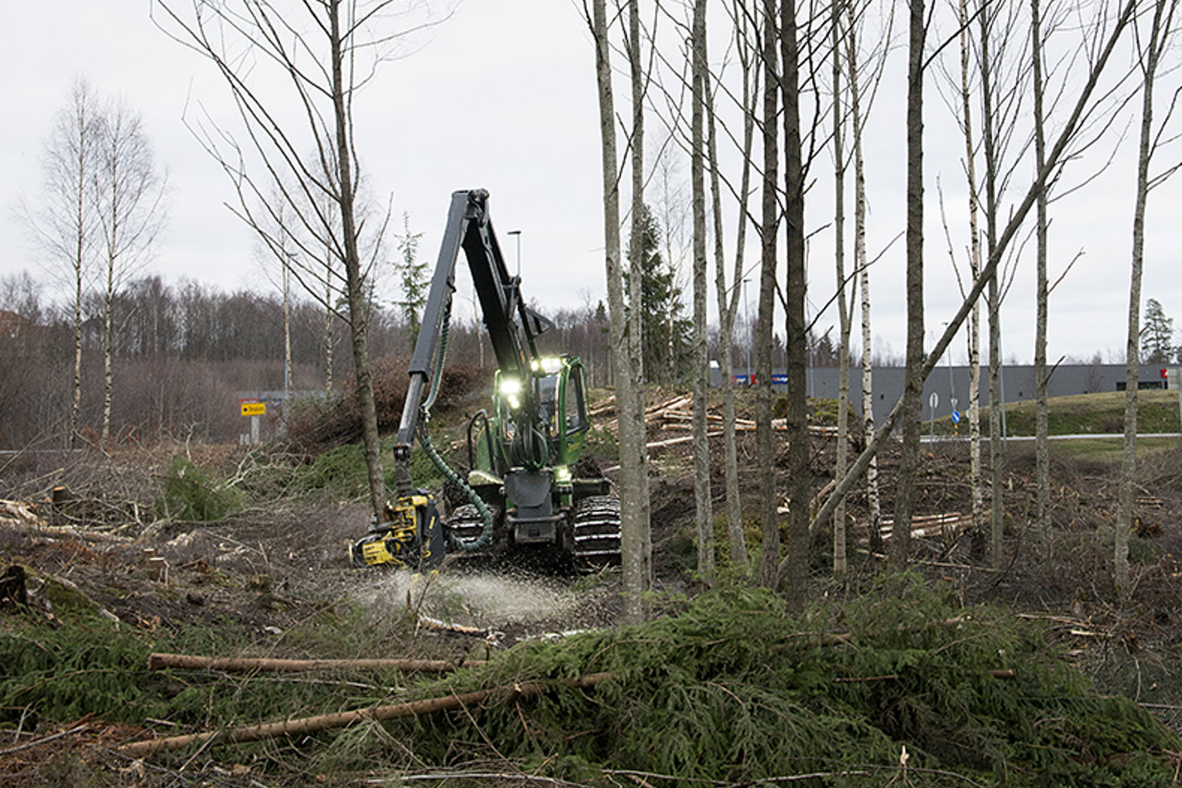 Hogstmaskin i skogen som rydder langs jernbanen. 