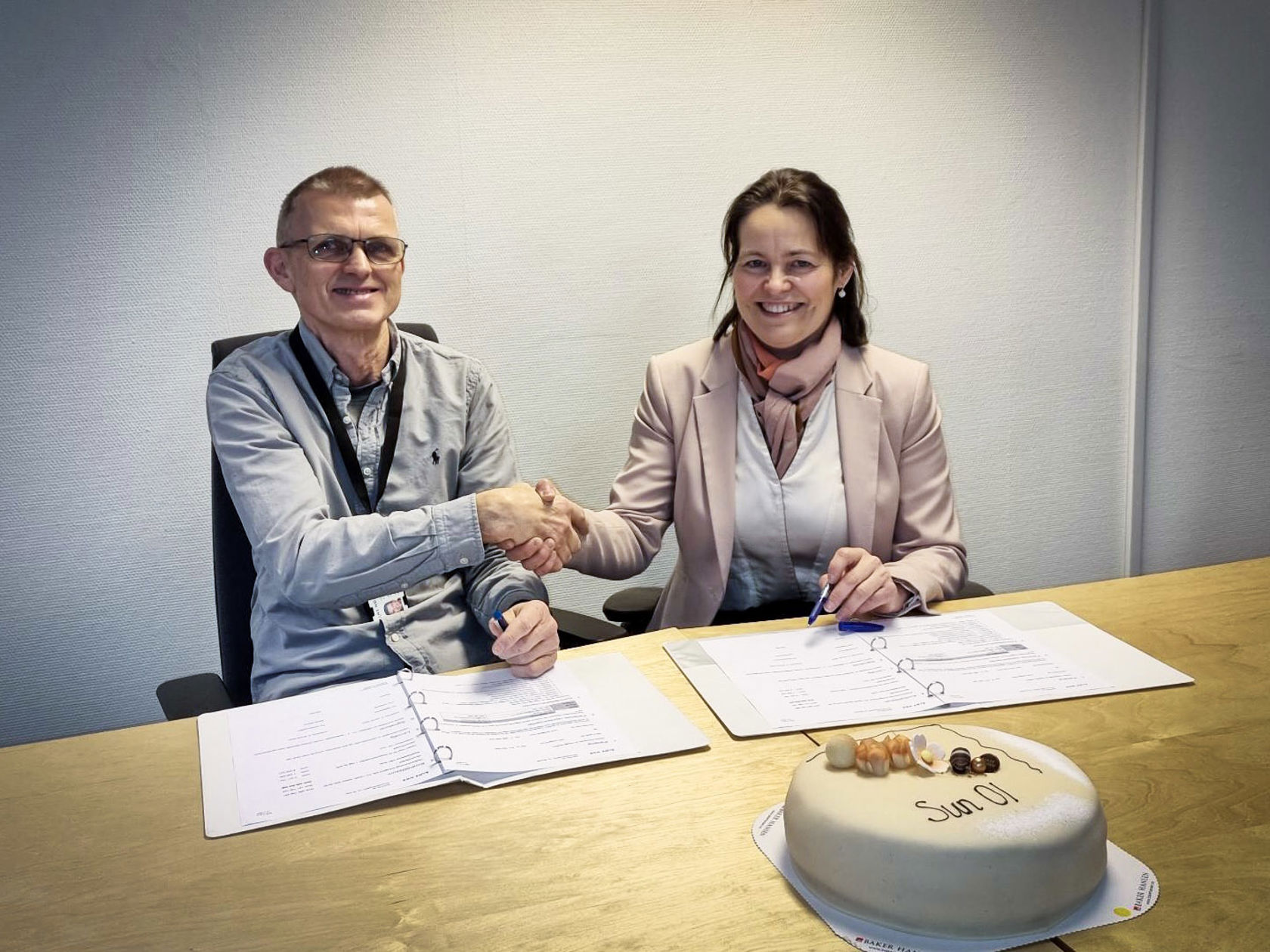 Bilde av to personer som tar hverandre i hånden.