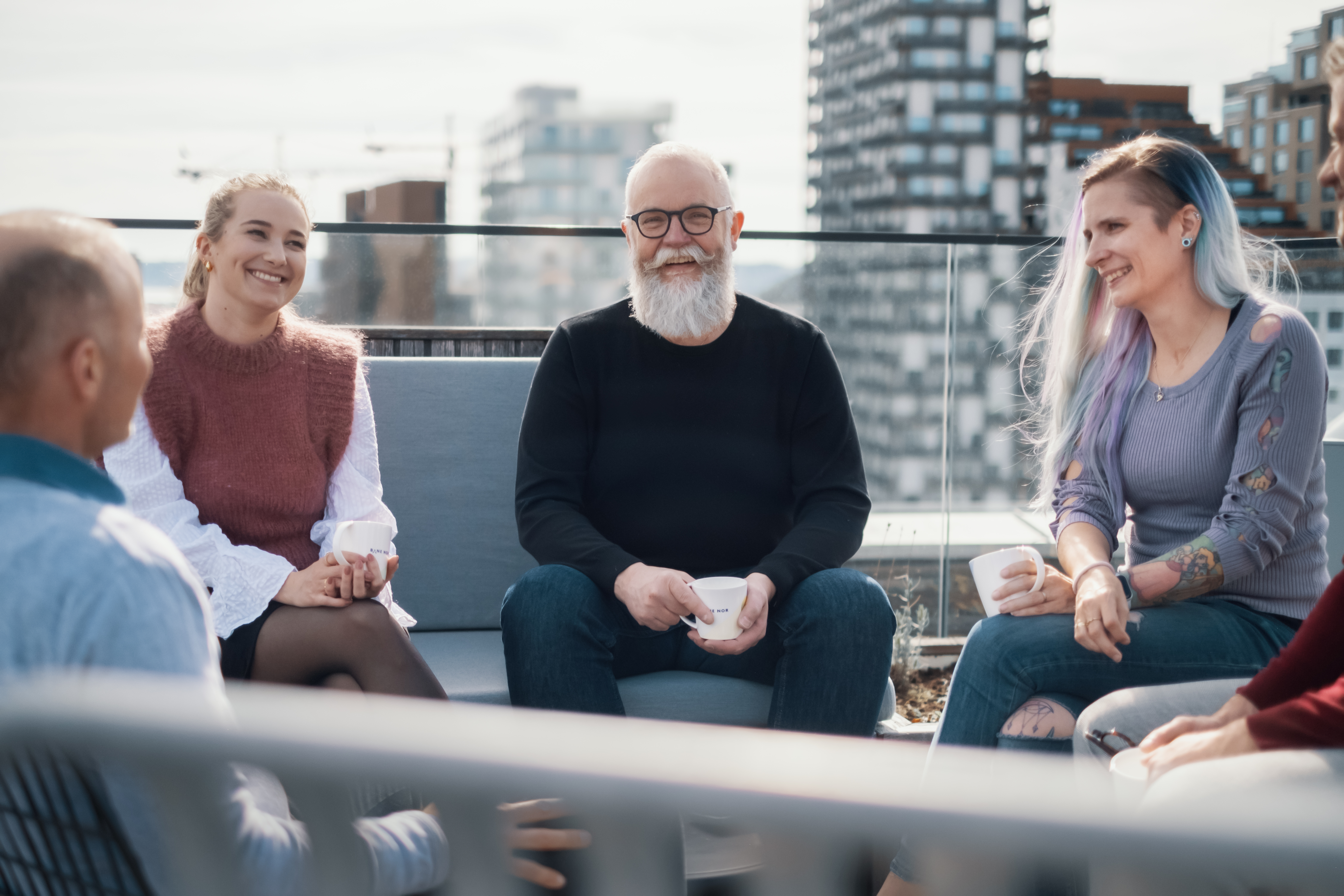 fire personer sitter på Bane NOR sin takterrasse på hovedkontoret i Oslo