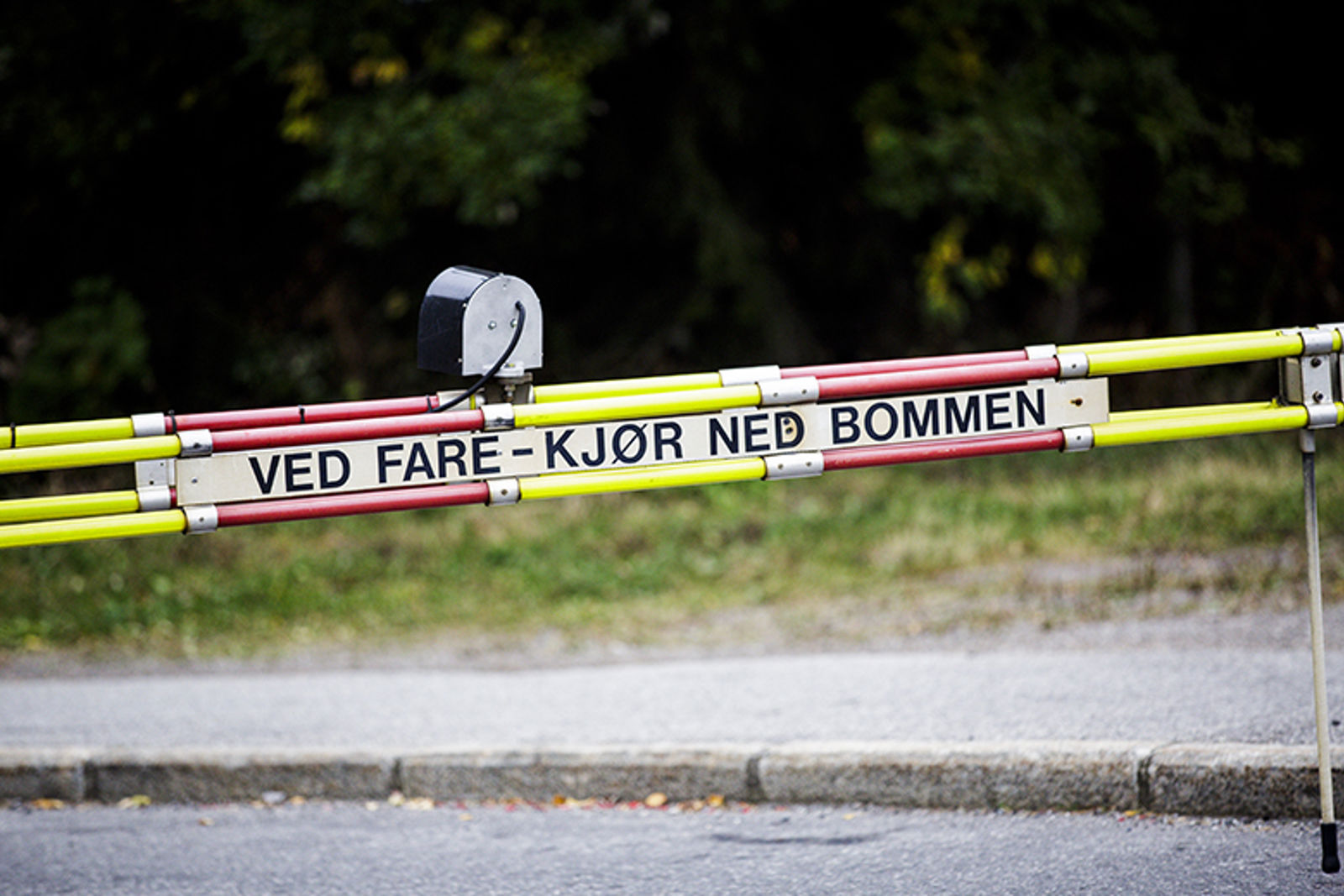 Bom med påskrift om å køyre ned bommen ved fare