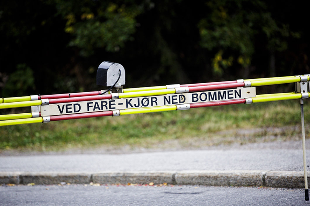 Bom med påskrift om å køyra ned bommen ved fare