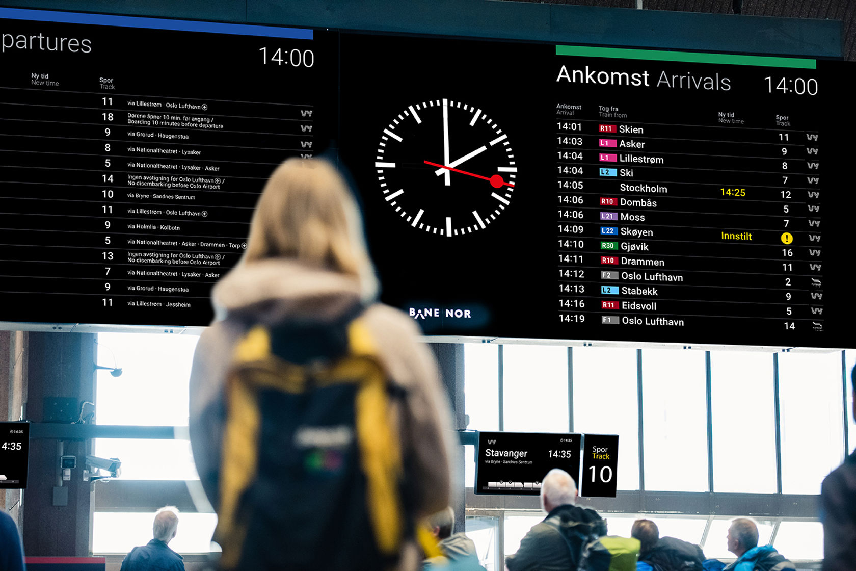 Bildet av en unk jente som ser på monitoren over avganger og ankomster på Oslo S.
